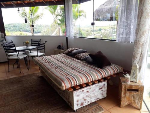a bedroom with a bed in a room with windows at Chalé Aconchegante em Piracaia in Piracaia