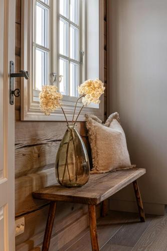 a vase sitting on a wooden table in a room at Log Cabin Near Historic Senhovd in Veggli