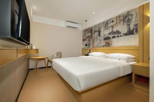 una camera da letto con un grande letto bianco e un tavolo di City Comfort Inn Nanning Guangxi University for Nationalities a Nanning