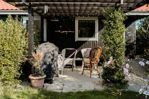a patio with a table and chairs on a house at Rosemary House Is A Peaceful Family Getaway in Rødvig