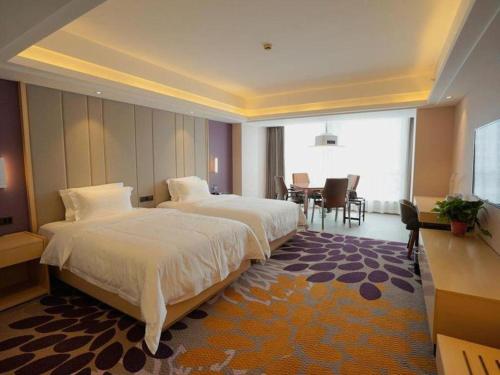 a hotel room with two beds and a dining room at Lavande Hotels· Yueyang Linxiang Zhongfa in Linxiang