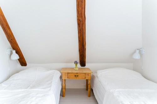 two beds in a room with white walls and wooden beams at Family-Friendly Oasis With Sea View In Funen in Nyborg