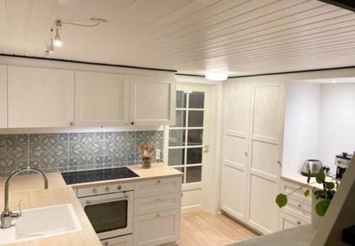 a kitchen with white cabinets and a sink at Atmosphere Close To Water Surrounded By Pines in Hvide Sande