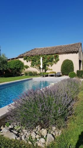 - une piscine en face d'une maison avec une statue dans l'établissement Provencal Farmhouse With Mont Ventoux Views, à Carpentras