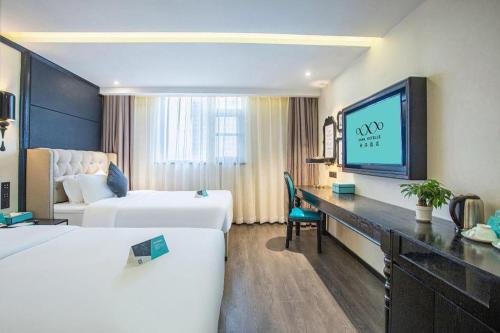 a hotel room with two beds and a flat screen tv at Xana Hotelle Nanchang Tengwang Pavilion Wanshougong in Nanchang