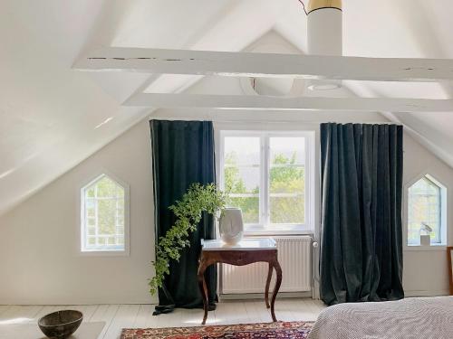 a bedroom with green curtains and a table and a window at Charming Artists House In Söderåkra in Söderåkra
