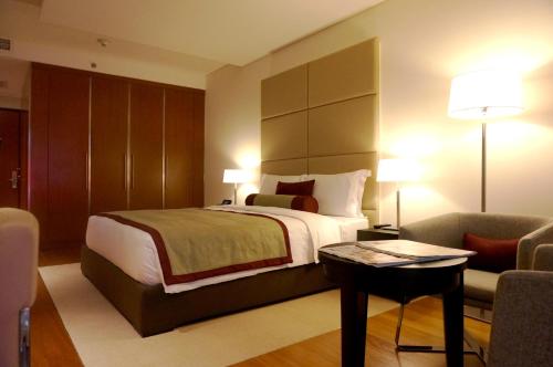 a bedroom with a bed and a couch and a table at Oryx Airport Hotel -Transit Only in Doha