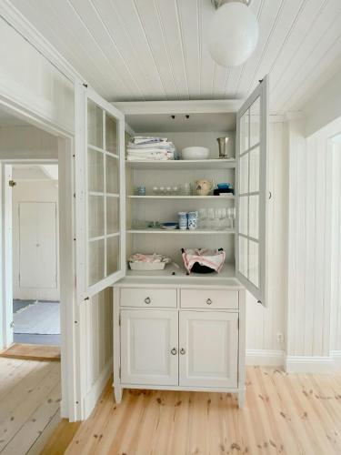 a white cabinet with a mirror in a room at Countryside Farm With Pool In Västergötland in Ljung