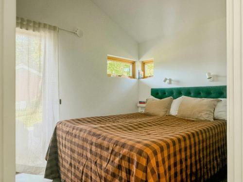 a bedroom with a bed with a checkered blanket at Modern Mini-Villa With Lake View On Bryggholmen in Enköping