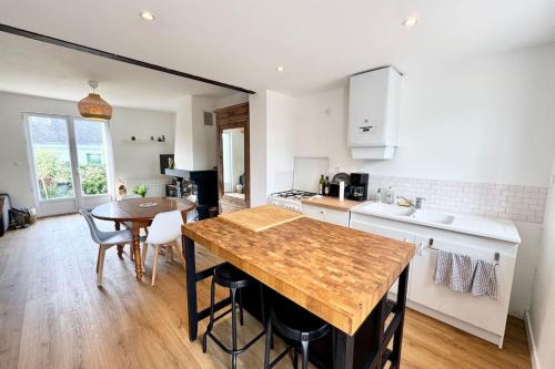 une cuisine avec une table en bois et une salle à manger dans l'établissement Escapade à Ploemeur Maison avec jardin et parking, à Ploemeur
