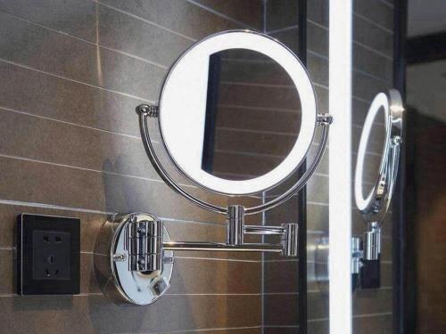 a mirror on the wall of a bathroom at Xana Hotelle Shenzheng South Station Foxconn in Shenzhen