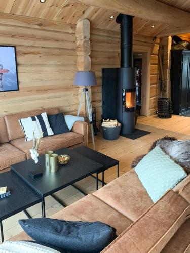 a living room with a couch and a fireplace at Luxury Log Cabin By Hardangervidda in Uvdal
