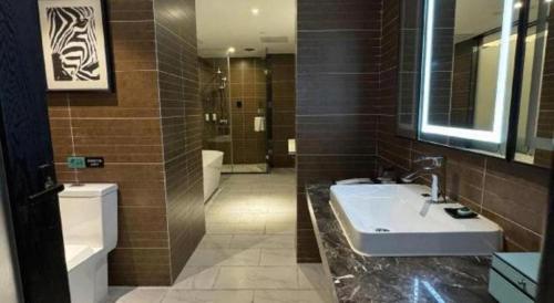 a bathroom with a sink and a toilet at Xana Hotelle Jinan Wuanfu Interchange Huafu International Square in Jinan