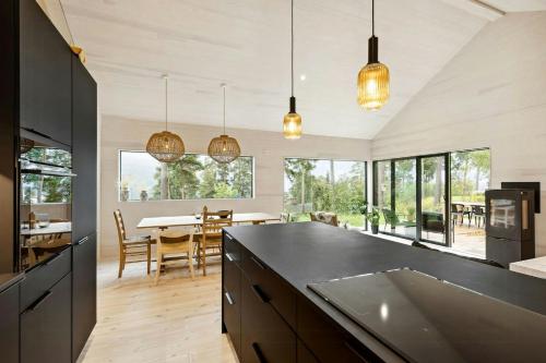 a kitchen with a black counter top and a dining room at New Cabin By Tyrifjorden For Relaxing Holidays in Gjesval