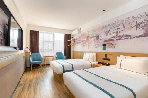 City Comfort Inn Zhanjiang Central People's Hospital High-speed Railway Station في Tchia-k'am: غرفة فندق بها سريران ومكتب