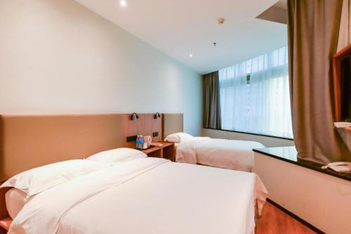 a hotel room with two beds and a window at GreenTree Inn Express Lanzhou West Passenger Station Lanzhou Center in Lanzhou