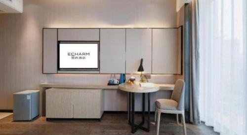a living room with a table and a table and chair at Echarm Hotel Nanning the MixC Dongmeng Business District in Nanning