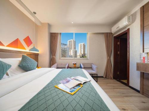 a hotel room with a bed and a view of a city at Borrman Hotel Yuxi Yuxing Road in Yuxi