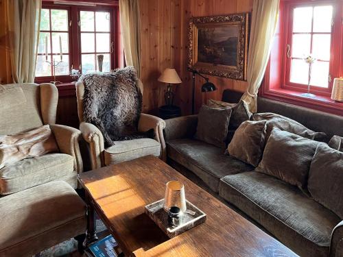Una sala de estar con sofás y una mesa de café. en Mountain Cabin Near Dovre With Panoramic View, en Oppdal