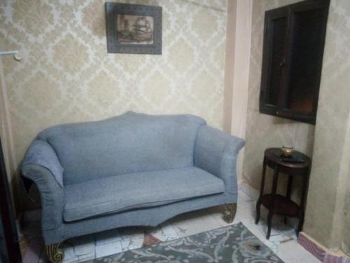 a blue couch in a living room with a television at Affordable downtown studio steps to sea free wifi in Alexandria