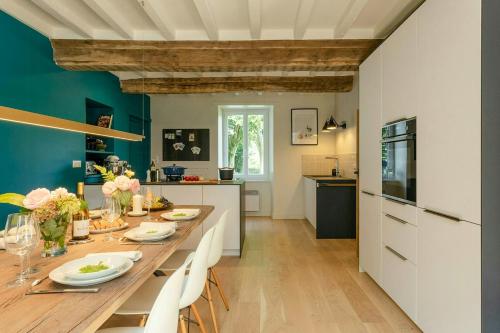 eine Küche und ein Esszimmer mit einem langen Tisch in der Unterkunft Renovated Stone House In Normandy in Sourdeval-les-Bois