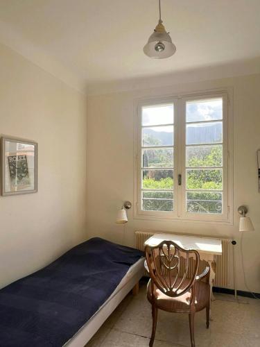 une chambre avec un lit, une chaise et une fenêtre dans l'établissement French Idyll In Authentic Village, à Villelongue-dels-Monts