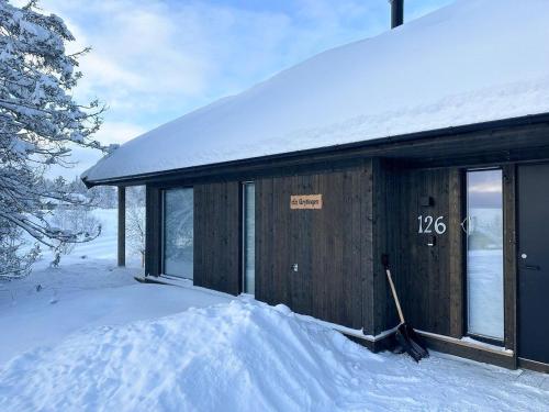 a cabin in the snow with a sign on it at Modern Mountain Cabin Near Syningtoppen in Torpo