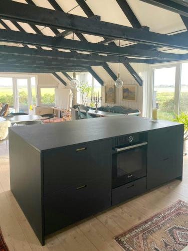 a kitchen with a black counter top in a living room at 13,000 Sqm Nature Plot Right Down To The Beach in Ringkøbing