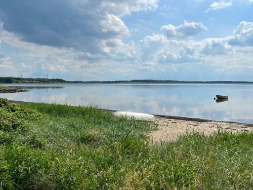 a boat sitting on the shore of a lake at Stunning Sunrises Over Harre Vig in Roslev