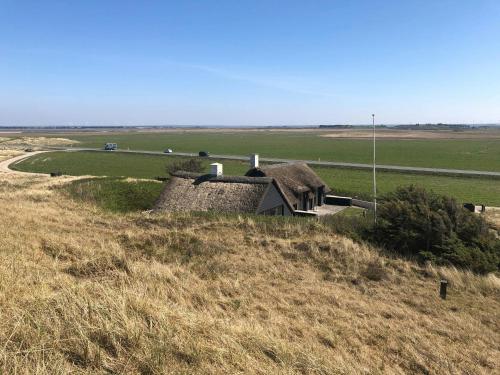 an old house on a hill in a field at 13,000 Sqm Nature Plot Right Down To The Beach in Ringkøbing