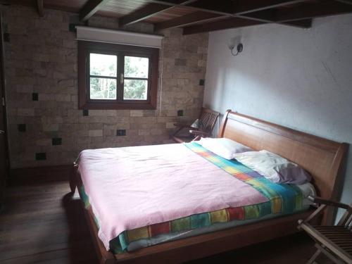 a bedroom with a bed in a room with a window at Chalet Colonia Tovar in Tovar