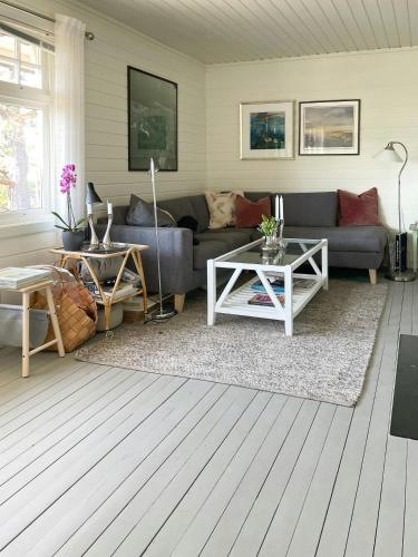 a living room with a couch and a table at Cozy Cabin With Sea View And Two Terraces in Tjøme