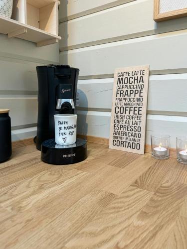 a coffee maker and a sign on a wooden floor at Charming Log Cabin Close To The Water And Hou in Hou