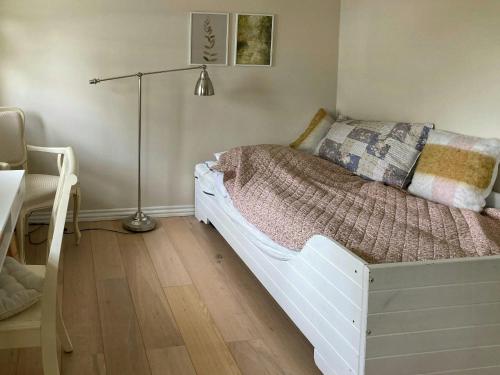 a bedroom with a bed and a table and a lamp at Charming Country House Near Holten Beach in Nysted