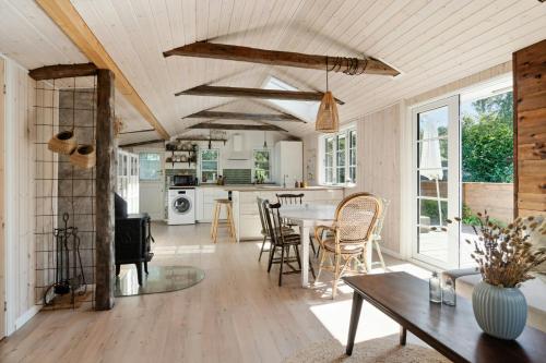 a kitchen and living room with a table and chairs at Peace Of Mind And A Smile On Your Lips At Havnsø in Føllenslev