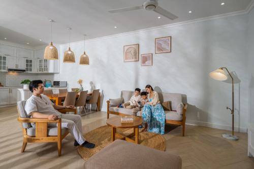 a group of people sitting in chairs in a living room at The Salt Villas Da Nang - 250sm 3BR, 4BA & Kitchen in Danang