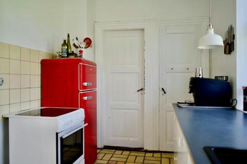 a kitchen with a red refrigerator and a sink at Former Railway Workers House By Kragenæs Harbour in Torrig