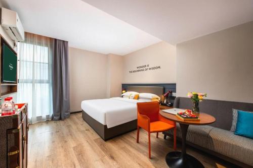 a hotel room with a bed and a table and a couch at City Comfort Premier Hotel Liuzhou Wuxing Pedestrian Street Jinggu Building in Liuzhou