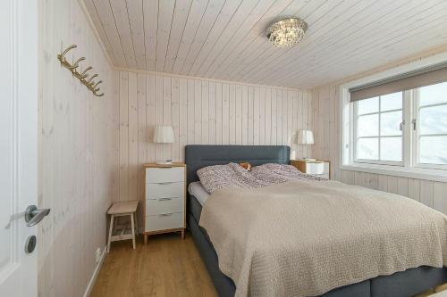 Un dormitorio con una cama azul y una ventana. en Family Cabin With Two Units At Sjusjøen, en Sjusjøen