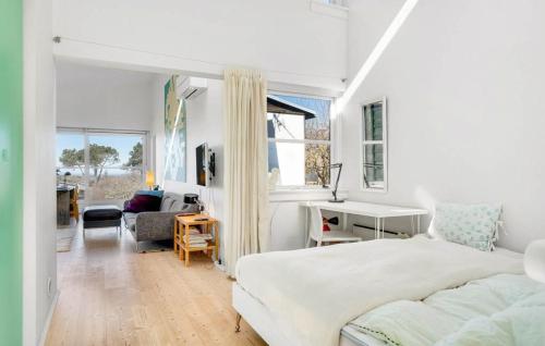 a white bedroom with a bed and a living room at Modern House With Sea View In Kårup in Fårevejle