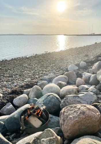 a group of rocks on a beach near the water at Historic House With Fjord View On Venø in Venø By