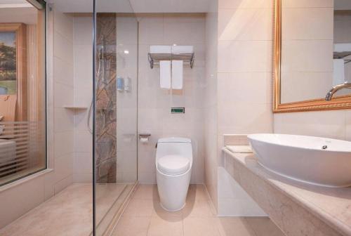 Un baño con lavabo, inodoro y ducha. en Vienna Hotel Hunan Jishou Fenghuang Ancient City, en Fenghuang