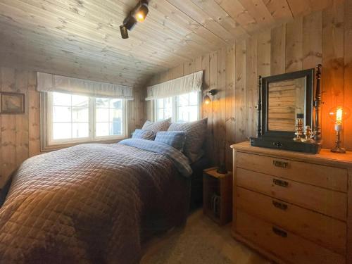 Un dormitorio con una cama y una cómoda con espejo. en Secluded Mountain Cabin In Rauland With View, en Rauland