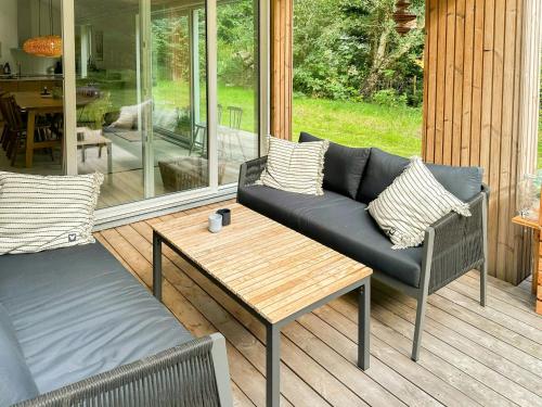 a patio with a couch and a coffee table at Bright Home Near Brødemose Forest With Views in Frederiksværk