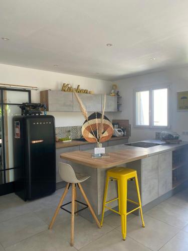 Il comprend une cuisine équipée d'une table et d'un réfrigérateur noir. dans l'établissement Peaceful Family Retreat In Aix-En-Provence, à Puyricard