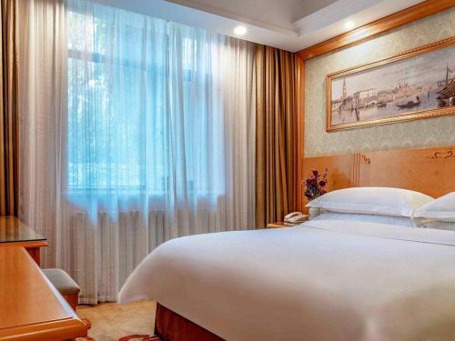 Ένα ή περισσότερα κρεβάτια σε δωμάτιο στο Vienna Hotel Urumqi Railway Administration Academy of Sciences