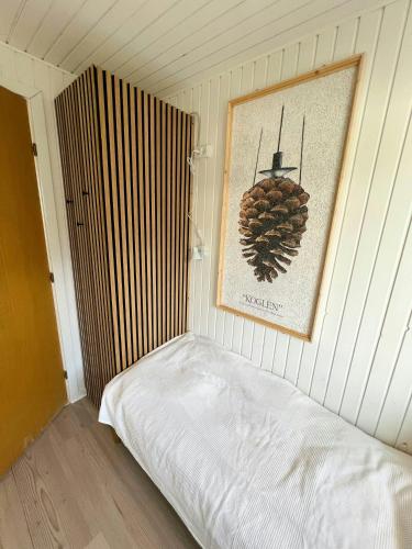 a bed in a room with a picture on the wall at Seaside Cottage With Ocean View At Flovt Beach in Haderslev