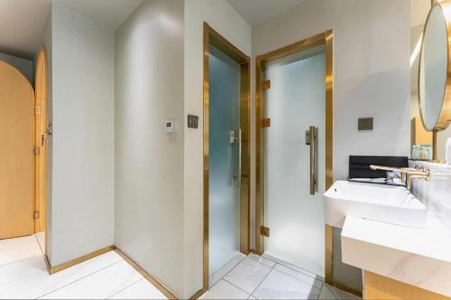 a bathroom with two sinks and two mirrors at Borrman Hotel Jining High-tech Huangtun in Jining