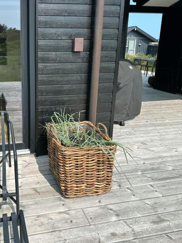 a wicker basket sitting outside of a house at Architect-Designed Holiday Home By Lønstrup Beach in Hjørring