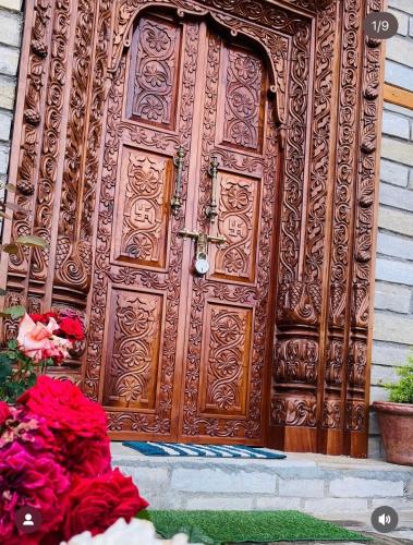 a large wooden door with flowers in front of it at Panchwati Farms Homestay in Almora